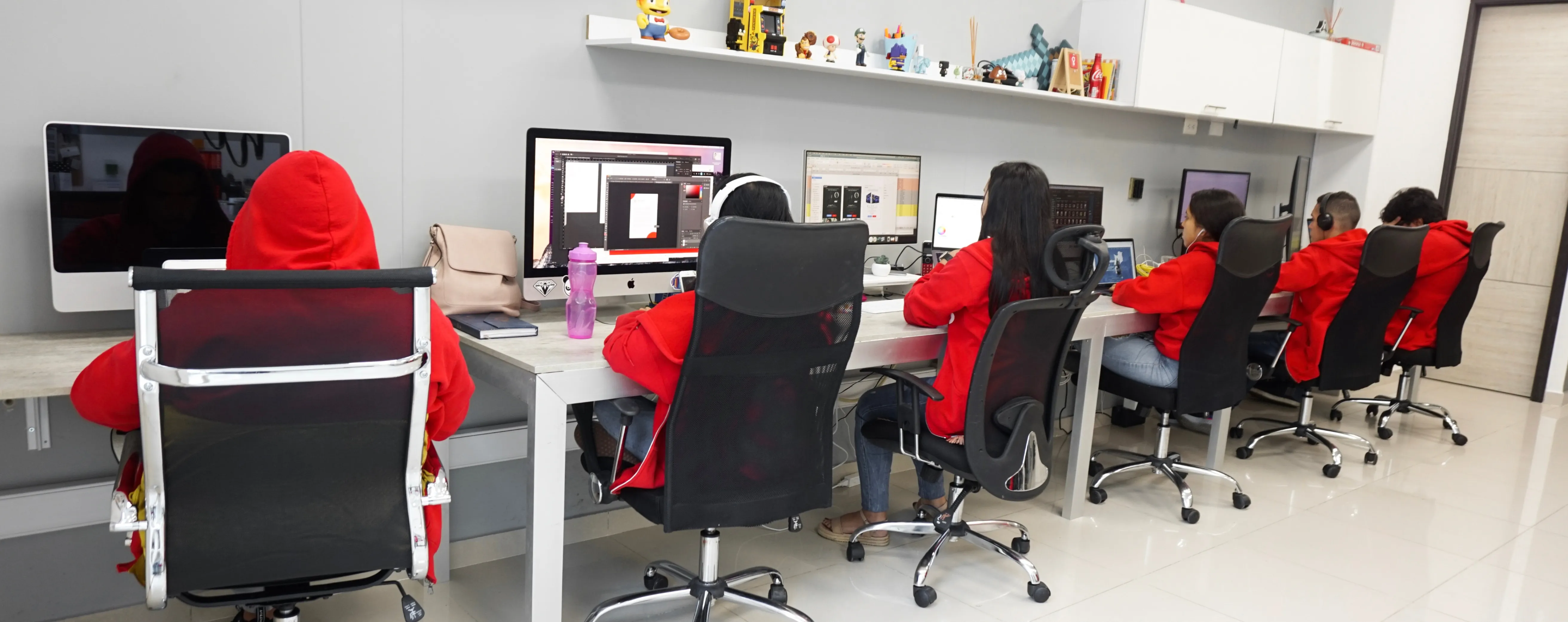 Office workspace with red and black chairs at computer workstations